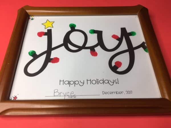 This easy-to-make Christmas gift for parents is perfect for pre-K through 1st grade and is a beautiful gift young students can give their parents for the holidays. Their fingerprints dipped in paint are the holiday lights around the word JOY.